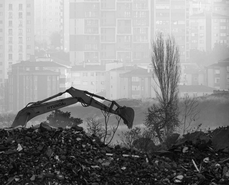 Black and white view of an excavator on a foggy site.